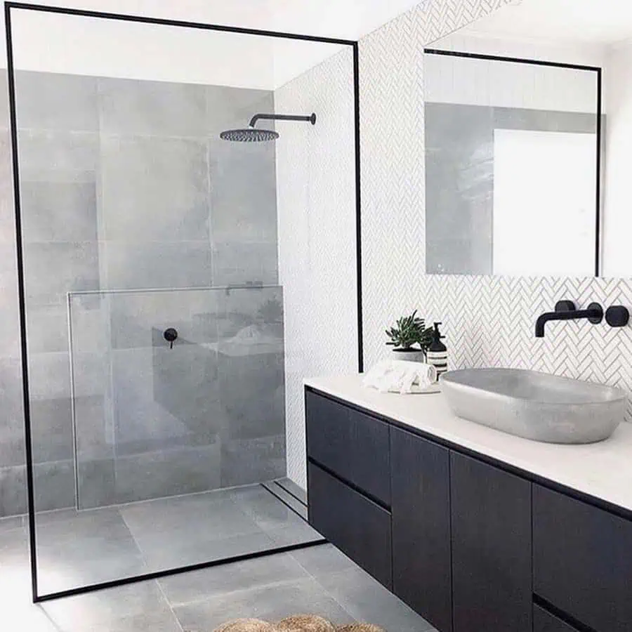 Scandinavian-inspired shower room with sleek black fixtures, concrete tiles, and a modern vanity sink.