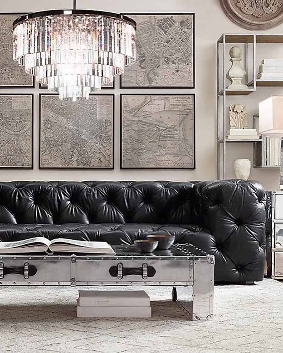 Scandinavian-style living room featuring a black tufted leather couch, metal coffee table, and a crystal chandelier.