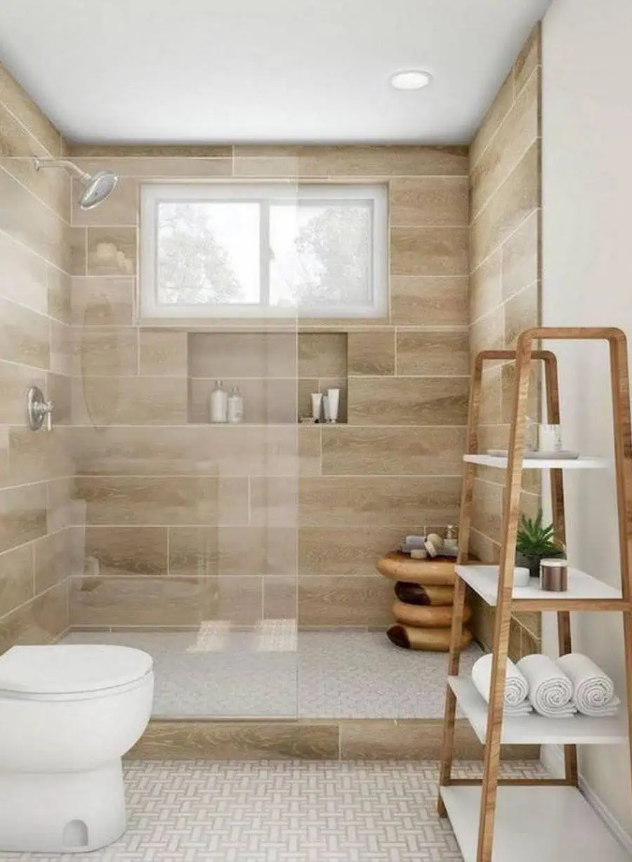 Modern bathroom with wood-look tiles, glass shower, and wooden ladder shelf for storage.