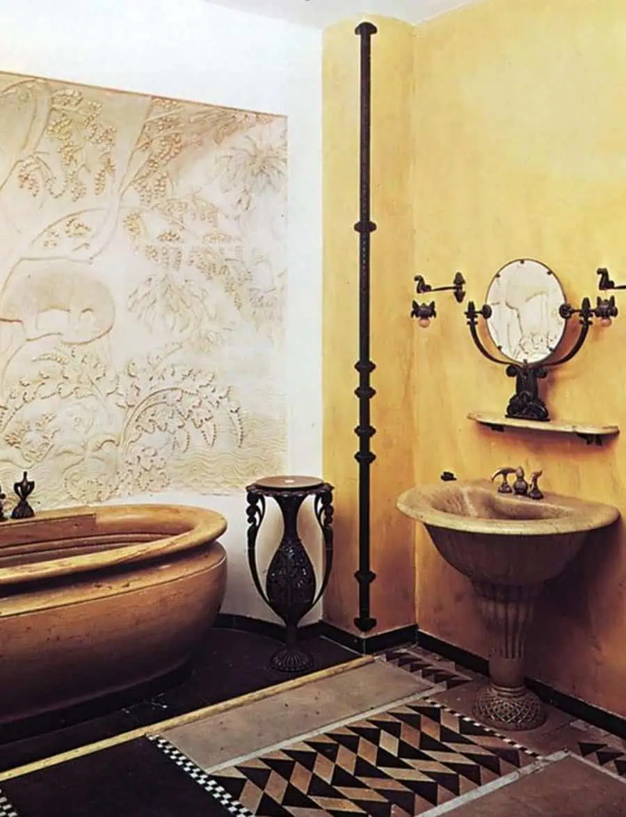 Rustic bathroom with carved stone tub, decorative sink, and textured walls featuring art.