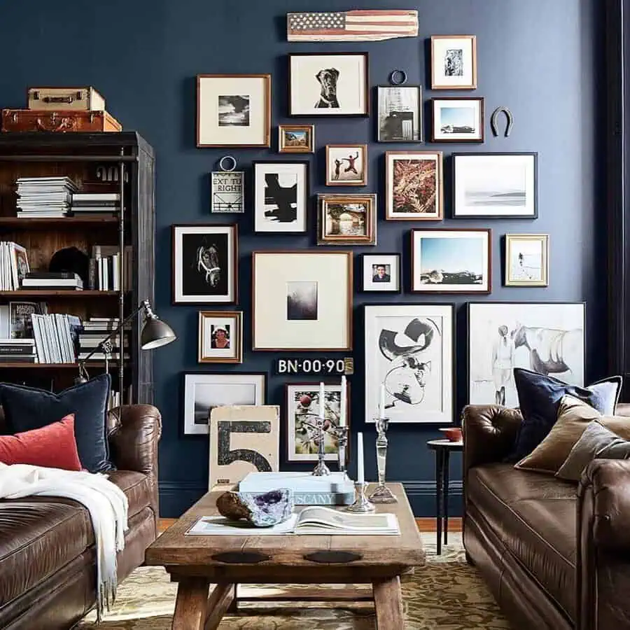 Eclectic gallery wall with unique frames, leather sofas, and vintage decor in a cozy living room setting.