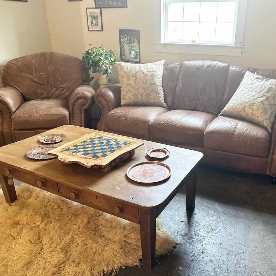Vintage leather sofa and armchair in a cozy room with a rustic wooden coffee table.