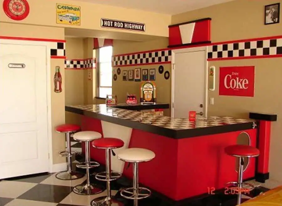 1950s diner-style kitchen with checkered countertops, red stools, and vintage Coca-Cola decor.