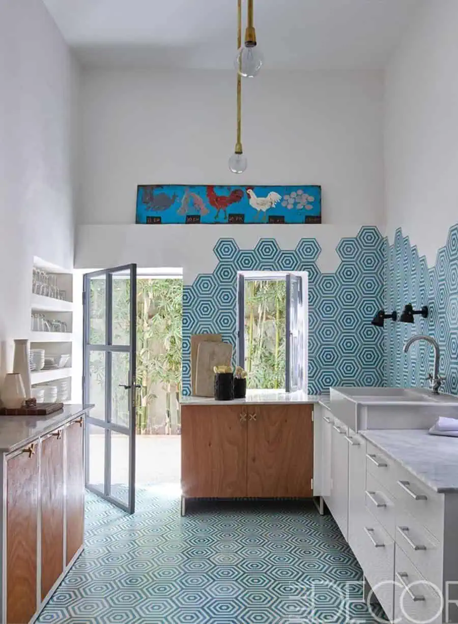 1950s kitchen with hexagonal blue tiles, wooden cabinets, and retro pendant lighting.