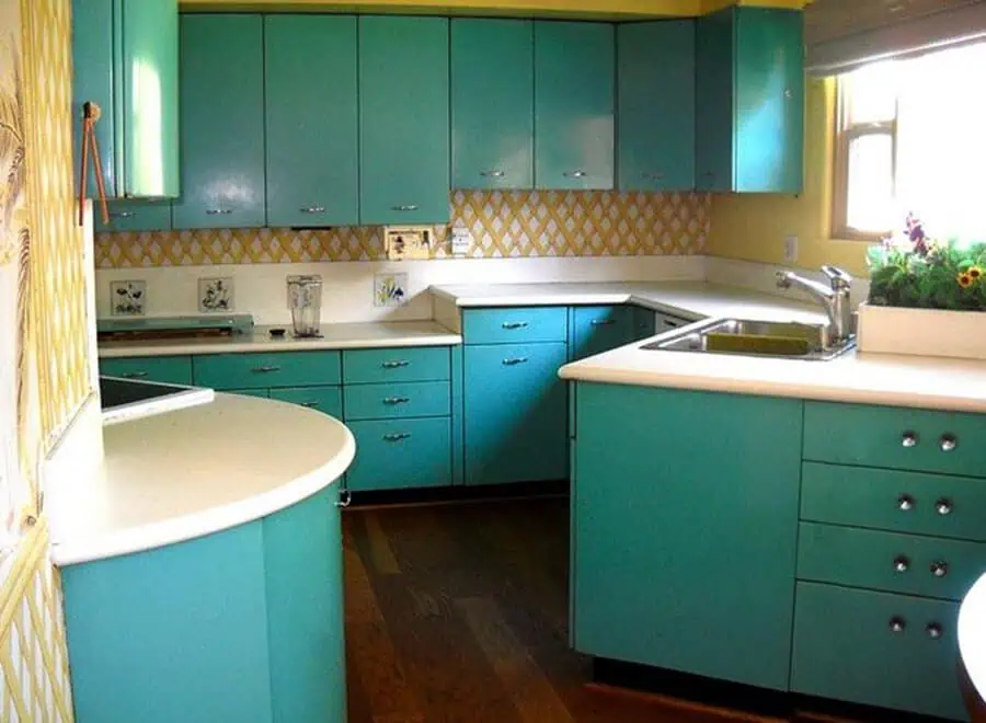 1950s kitchen with turquoise metal cabinets, yellow backsplash, and retro countertop design.