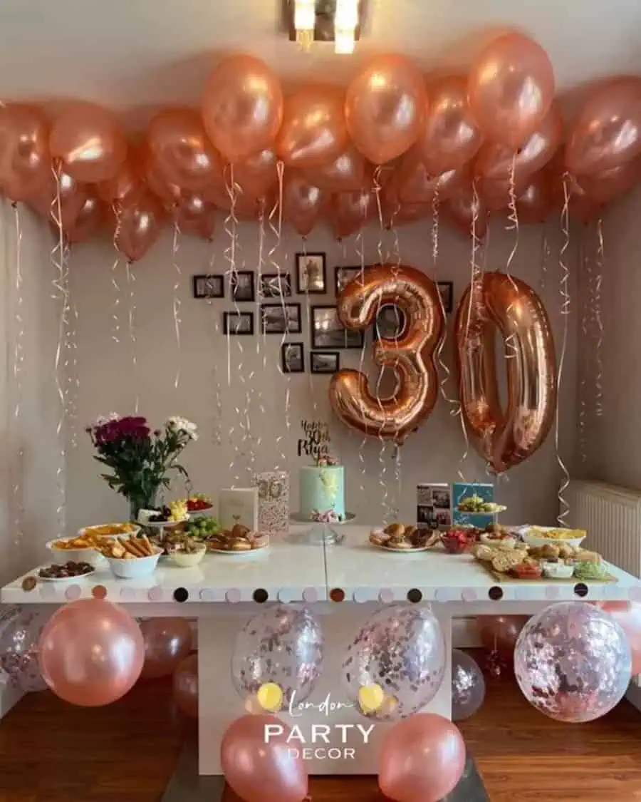 Rose gold balloon decor with a chic brunch table setup for a 30th birthday celebration.