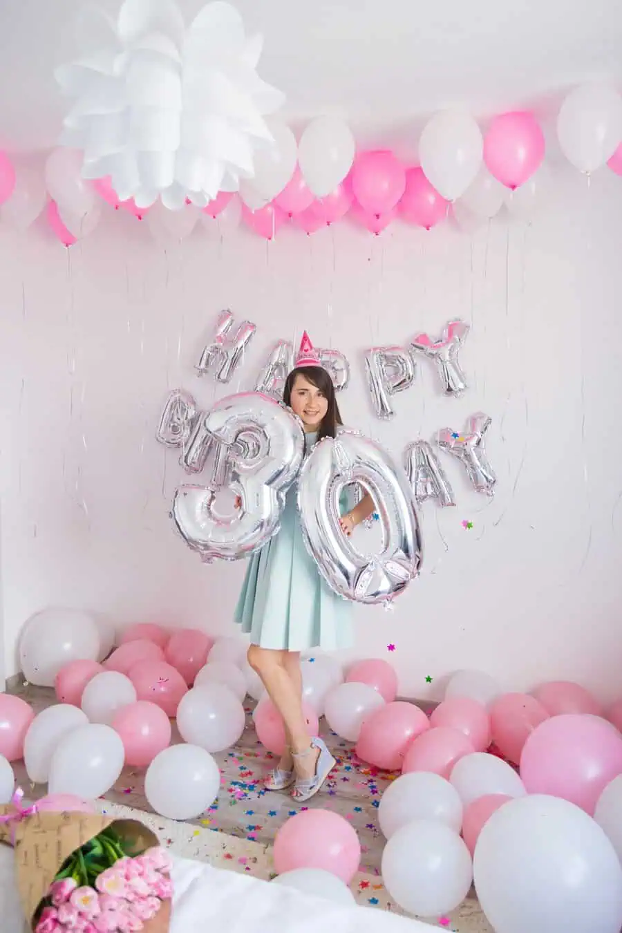 Pink and white balloon decor with silver "30" and Happy Birthday backdrop for a celebration.