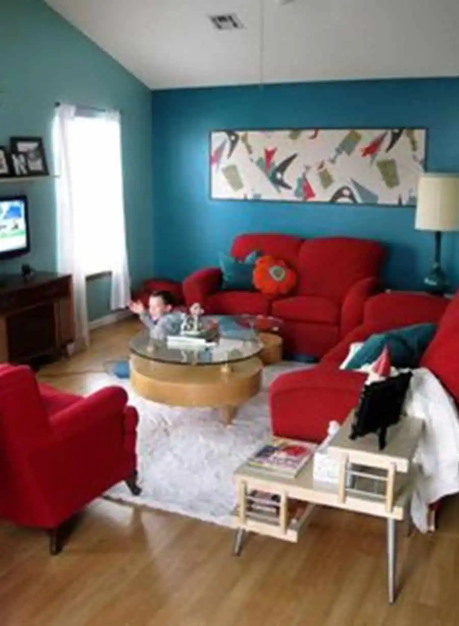 Colorful living room with teal walls, bright red furniture, and vibrant decor accents.