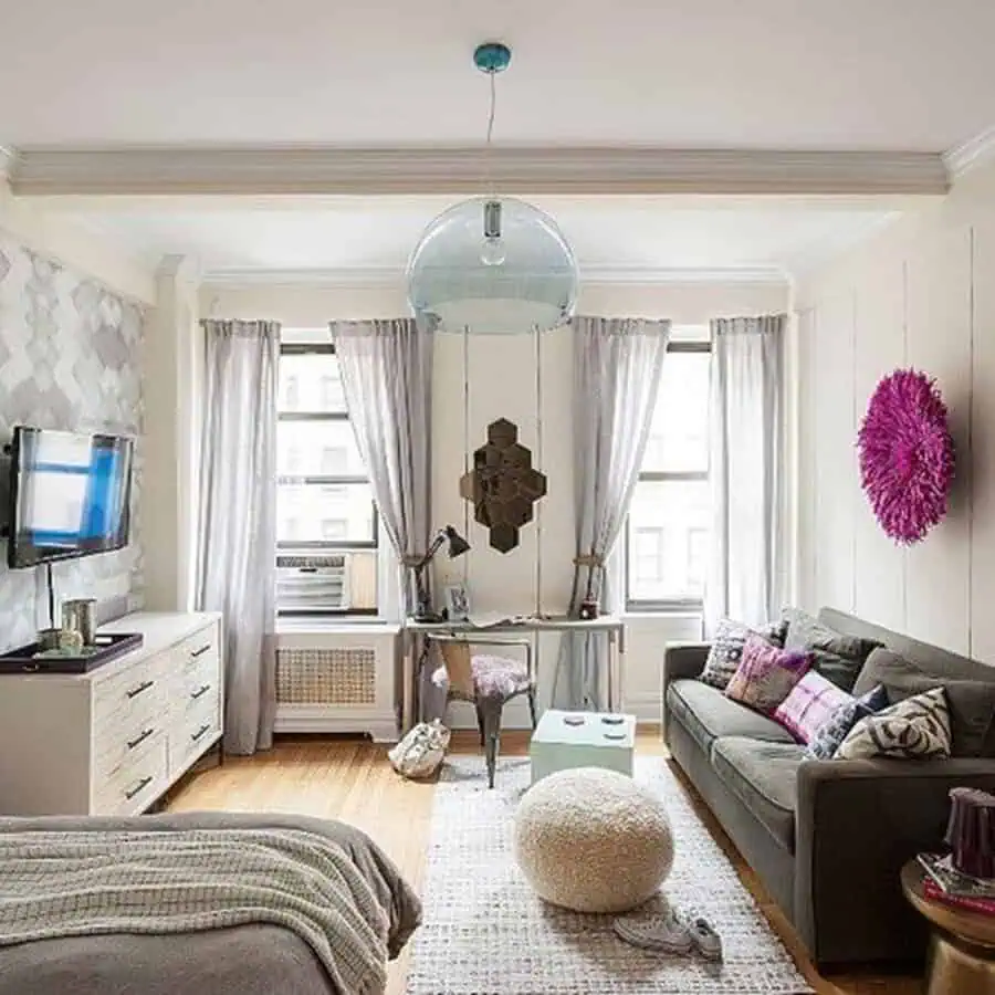 Classy studio with gray sofa, desk by the window, textured walls, and cozy modern decor.