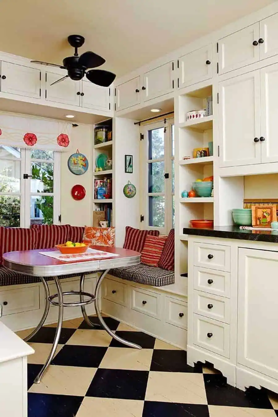 1950s kitchen with a cozy dining nook, checkered floor, and built-in white cabinets.