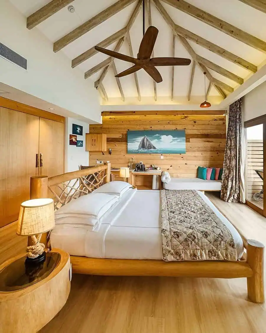 Cozy bedroom with wooden decor, vaulted ceiling, and romantic couple's retreat design.