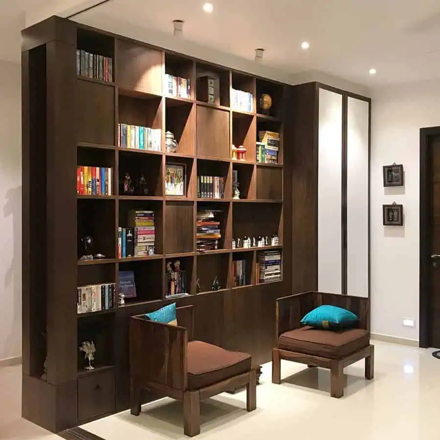 Cozy nook with wooden bookshelves, modern chairs, accent pillows, and ambient lighting.






