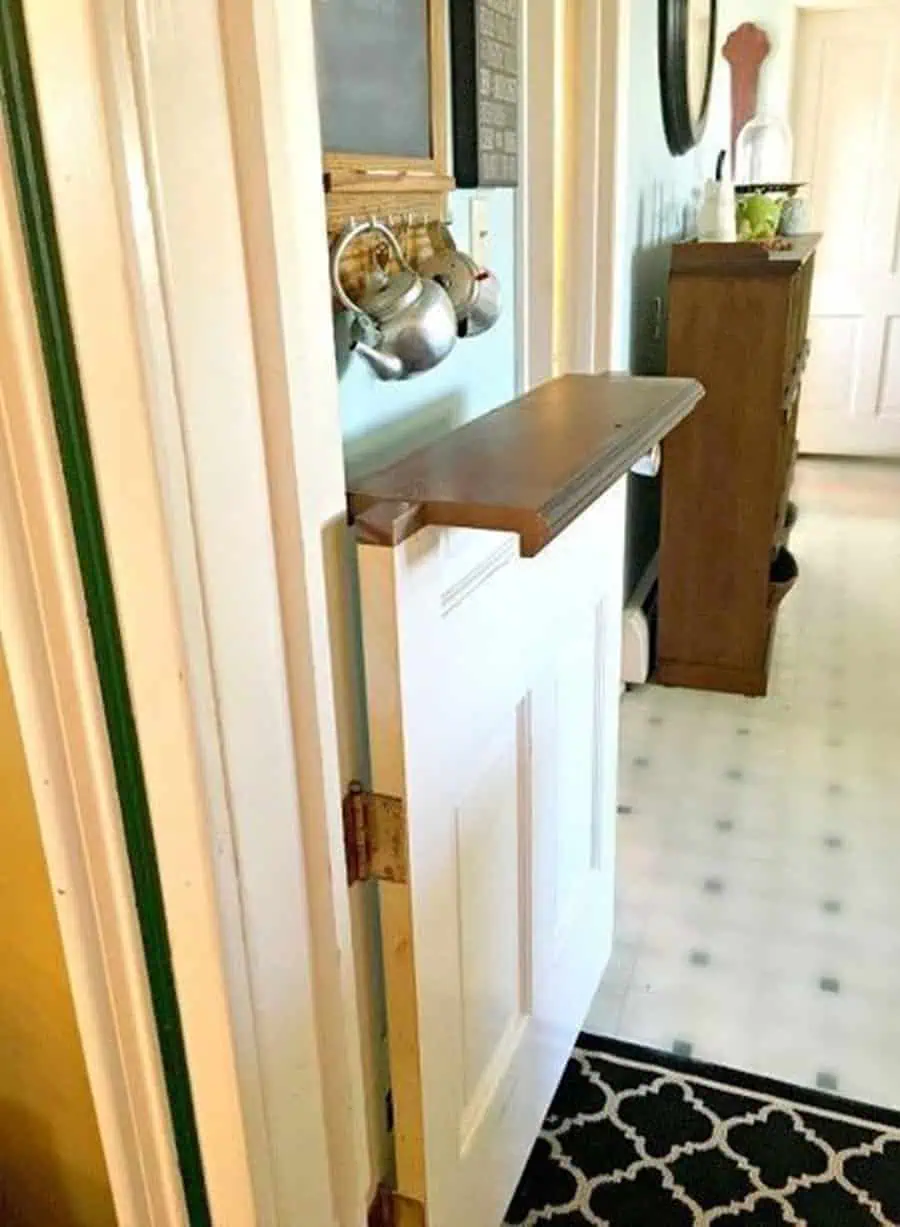 DIY white Dutch door with a wooden shelf, open to reveal a cozy interior hallway.