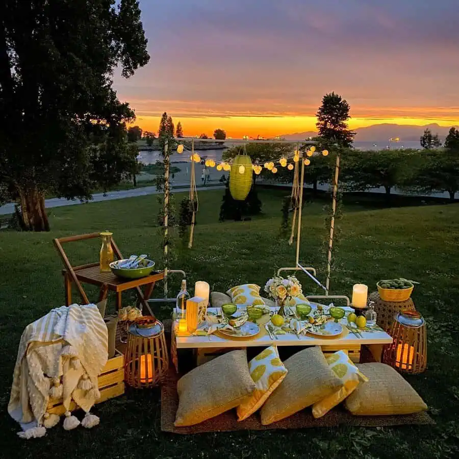 Sunset outdoor birthday party with cozy seating, string lights, and elegant table decor.