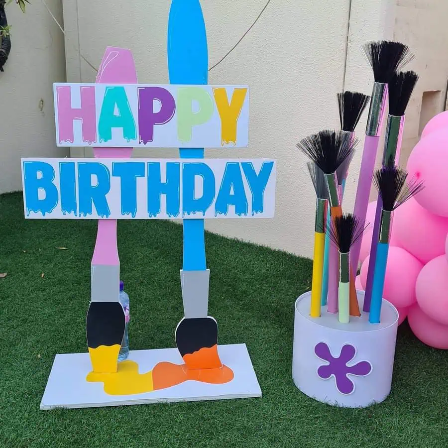 Painting-themed birthday decoration with colorful brushes and “Happy Birthday” sign.