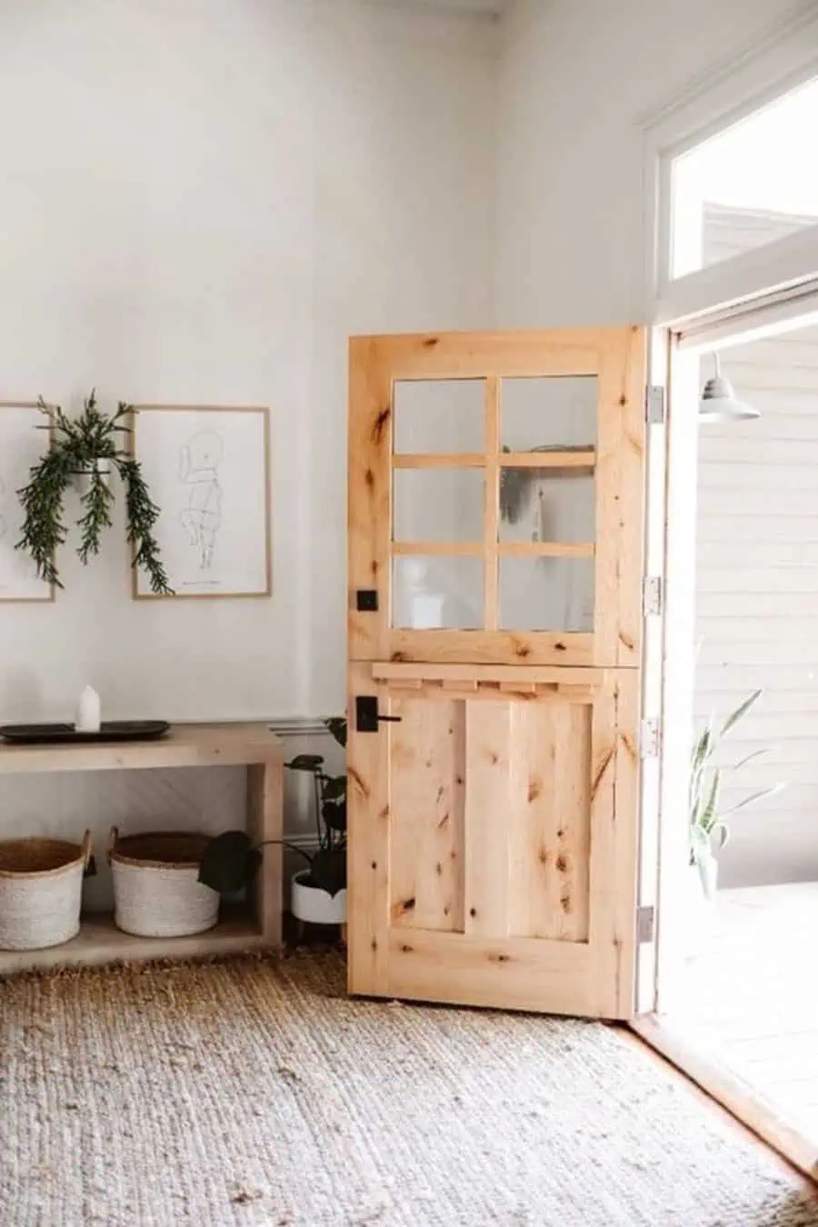 Natural wood Dutch door with glass panes, white walls, and minimalist interior decor.