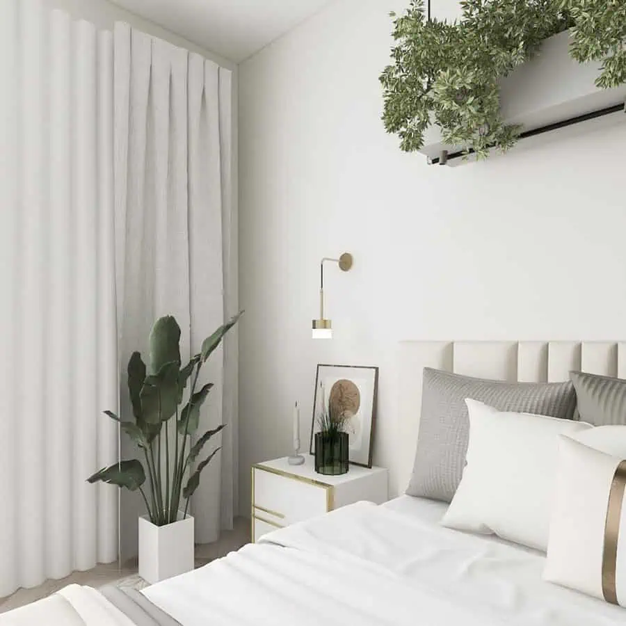 A serene bedroom featuring minimalist decor with soft white tones, greenery accents from hanging plants, and a modern aesthetic.