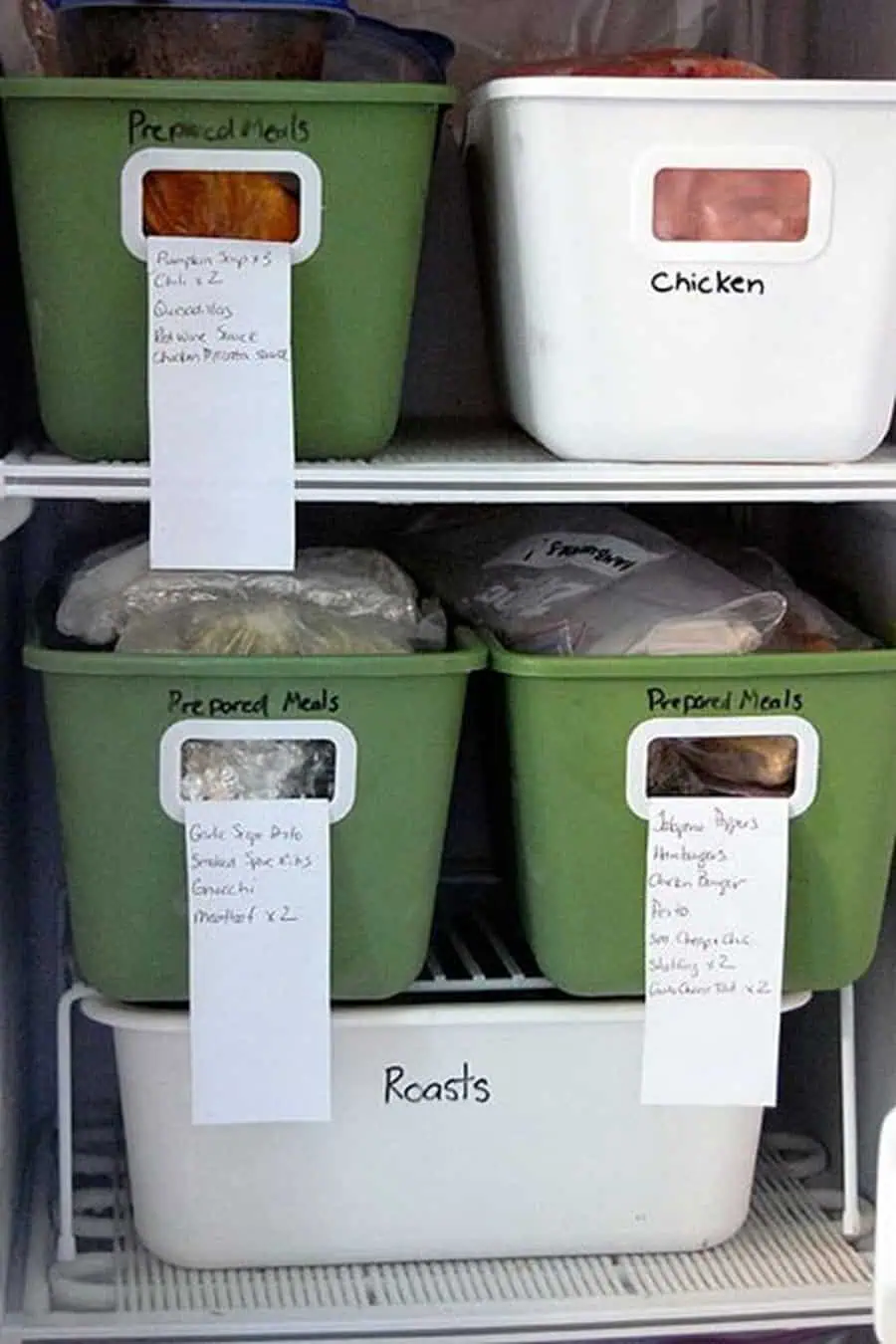 Labeled bins for prepared meals, chicken, and roasts neatly organized in a freezer.