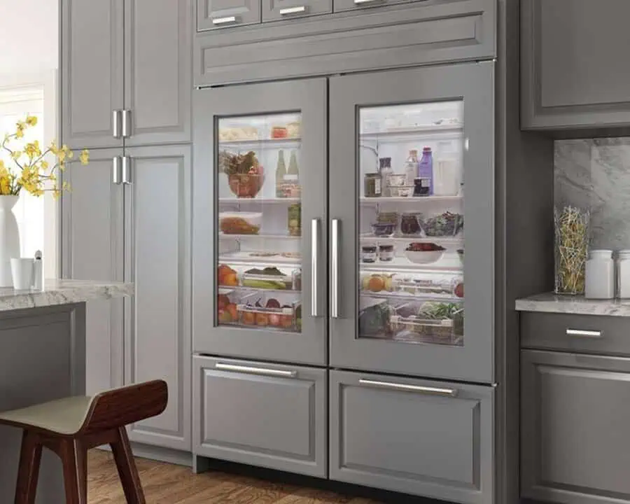 Modern kitchen with a double-door glass refrigerator showcasing neatly organized shelves.