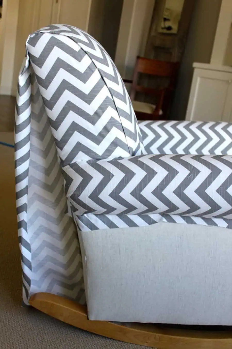 Photo of a reupholstered rocking chair with chevron-patterned fabric and a sleek finish.