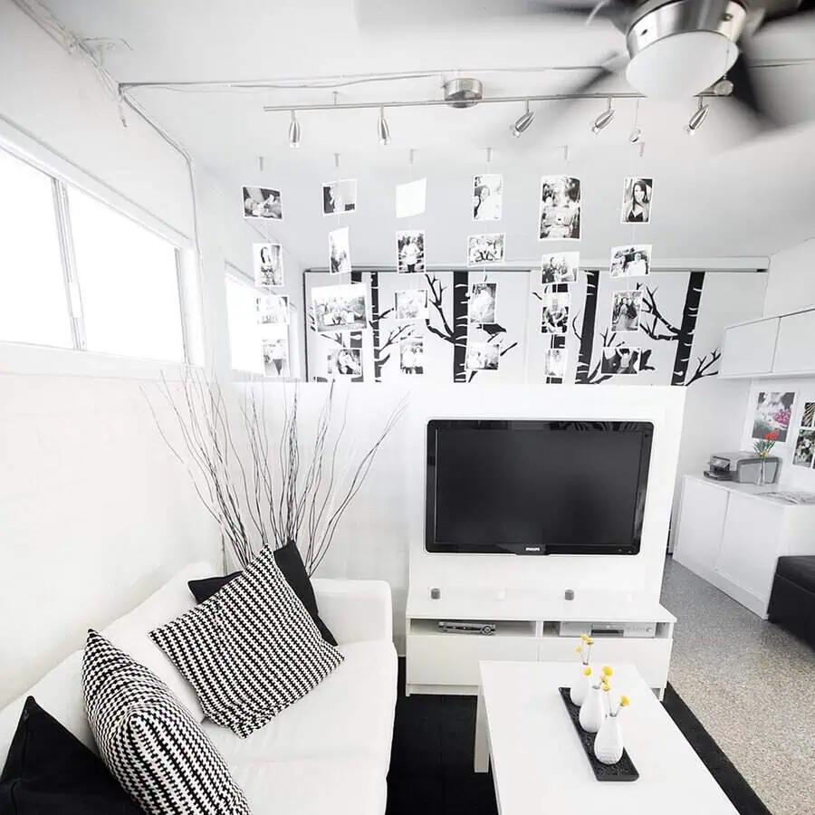 Black and white studio apartment with modern decor, photo wall, and minimalist furniture.