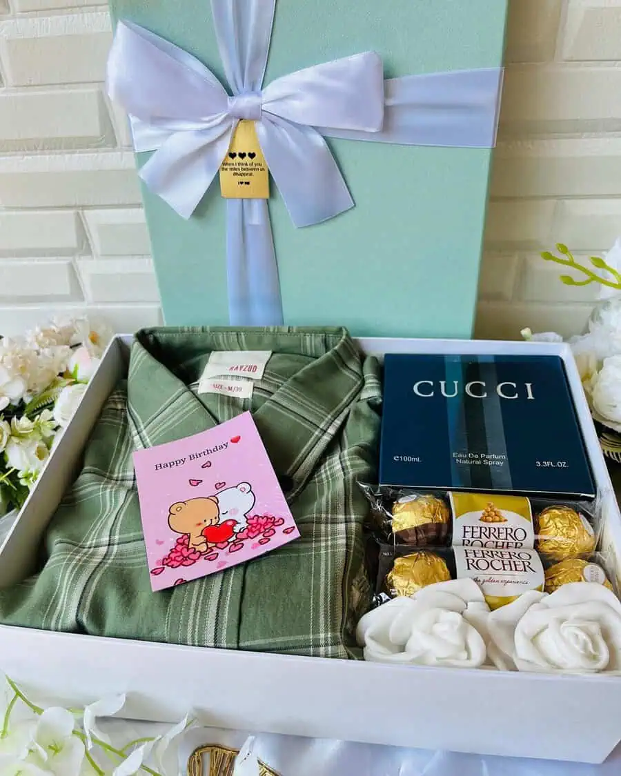 Luxury birthday gift box with a shirt, perfume, chocolates, and decorative roses.