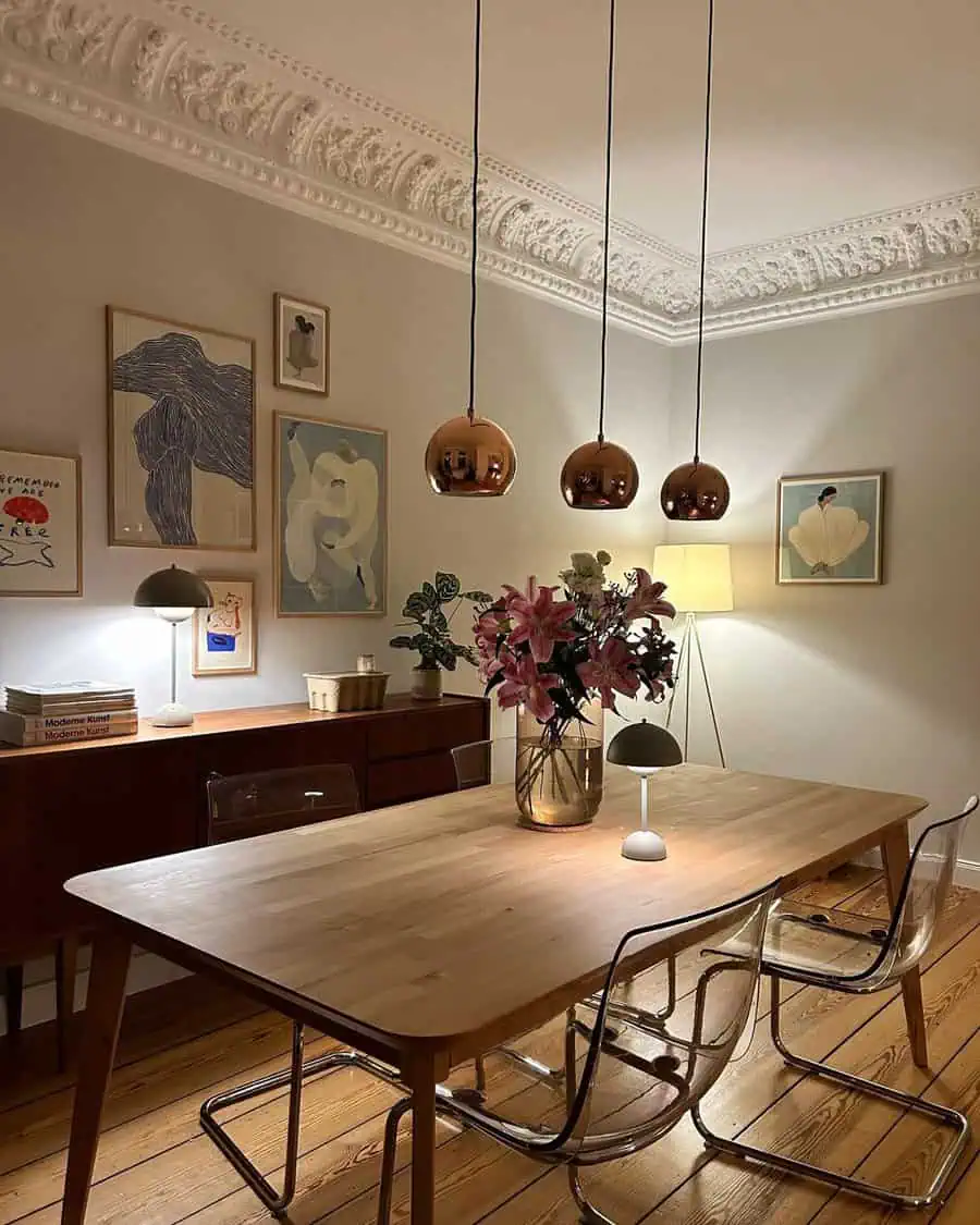 Eclectic dining room with mid-century furniture, pendant lights, and an art-filled gallery wall.
