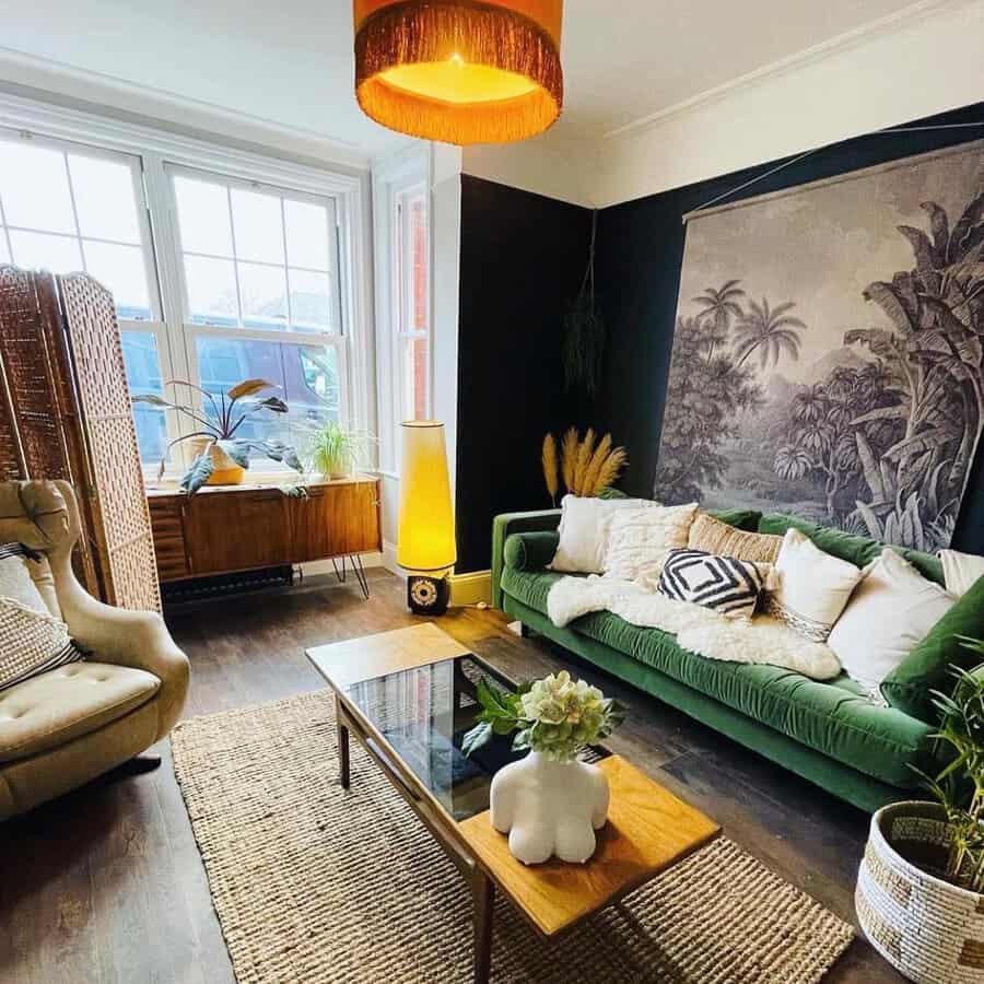 Eclectic living room with green velvet sofa, tropical wall art, and warm lighting accents.