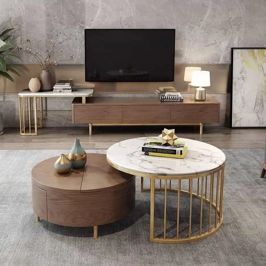 Elegant living room with marble and wood coffee tables, a TV unit, and gold accent decor.