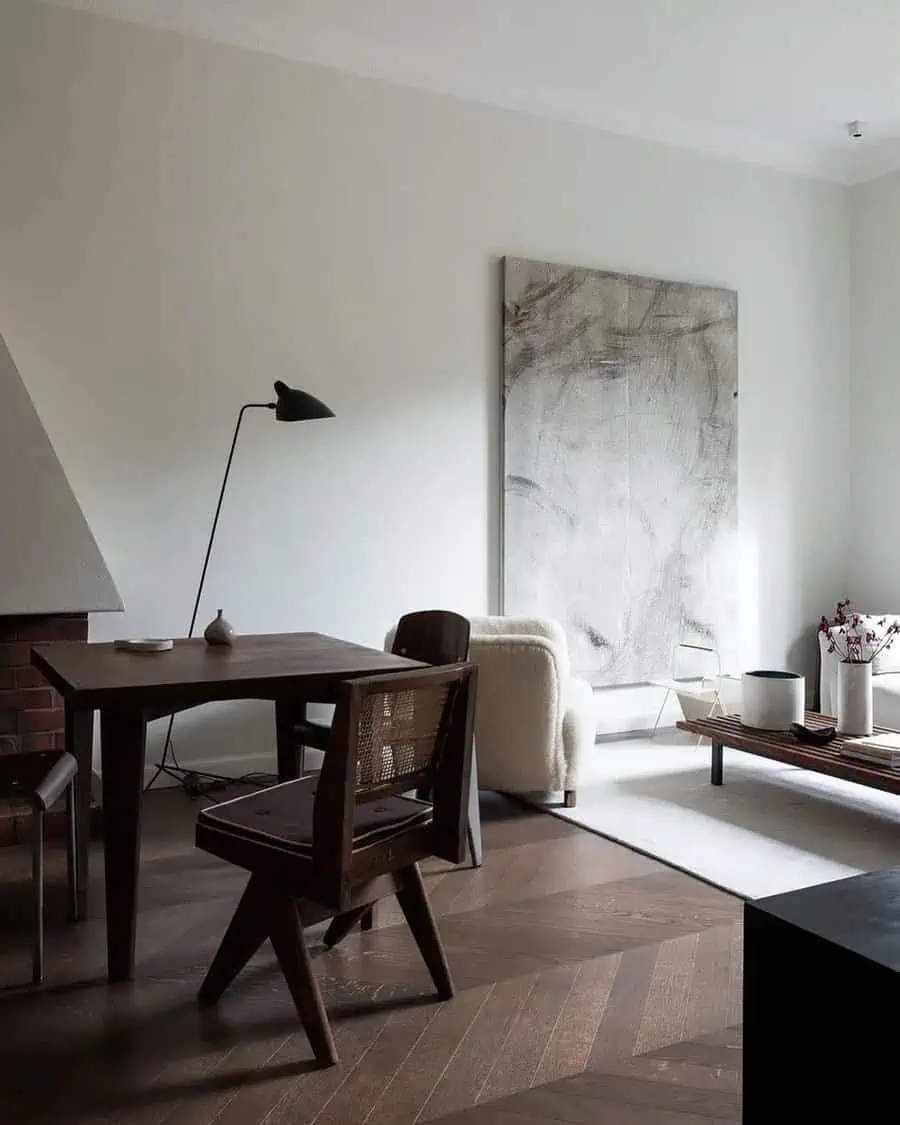 Modern living space with dark wood furniture, abstract wall art, and chevron-patterned flooring.