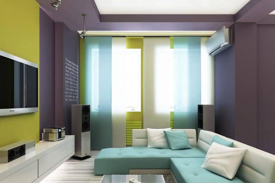 Modern living room with vibrant green and purple walls, a sectional sofa, and home entertainment setup.