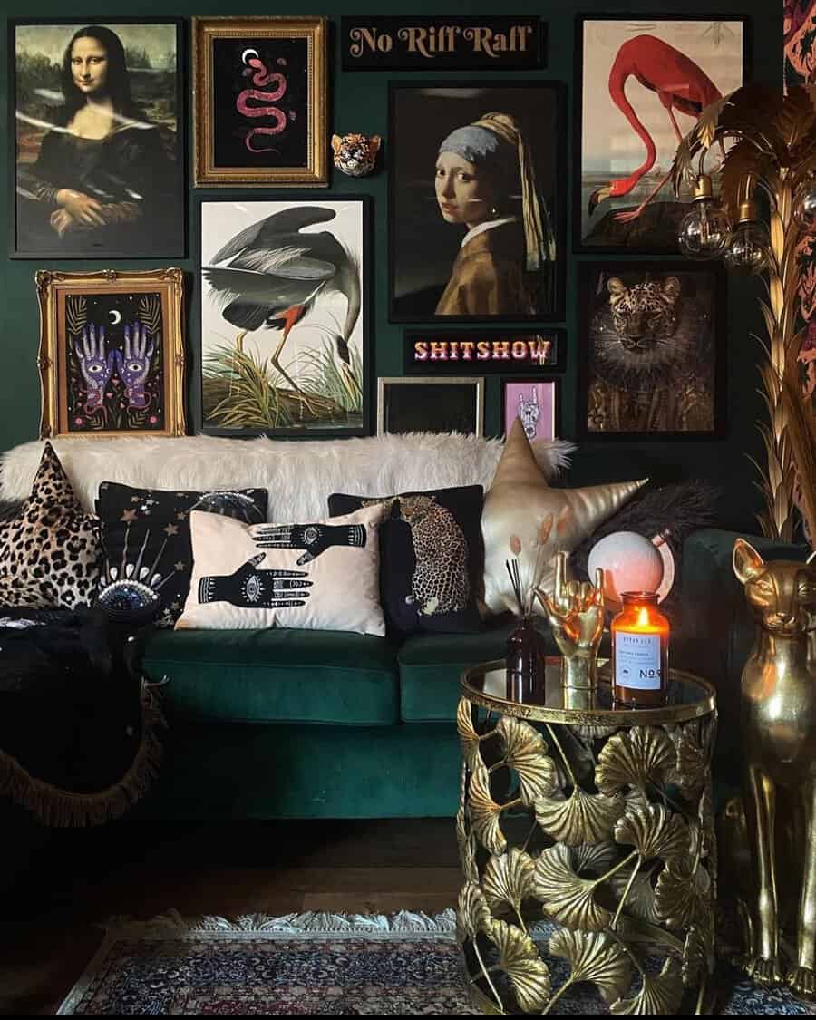 Dark eclectic living room with bold gallery wall, velvet sofa, and ornate gold decor accents.