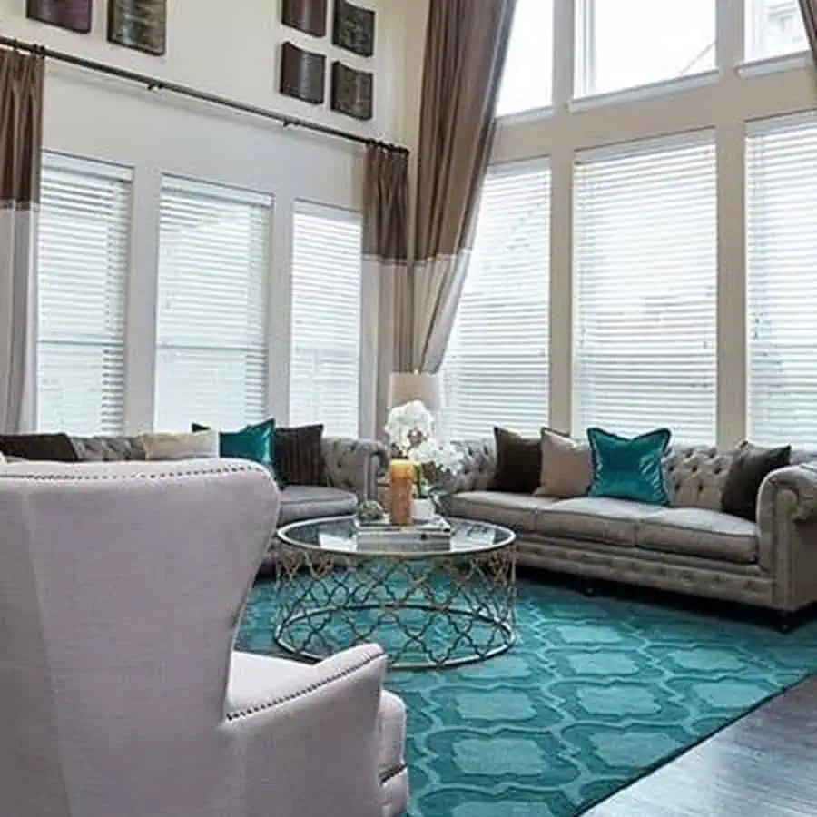 Luxurious living room with a teal Moroccan-style rug, tufted gray sofas, and elegant gold-accented decor.