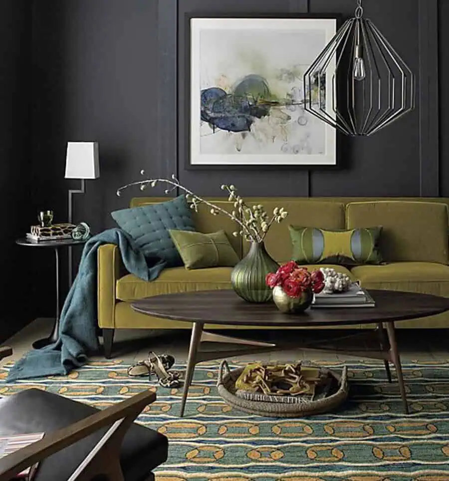 Living room with olive green sofa, teal accents, abstract artwork, and a patterned area rug.