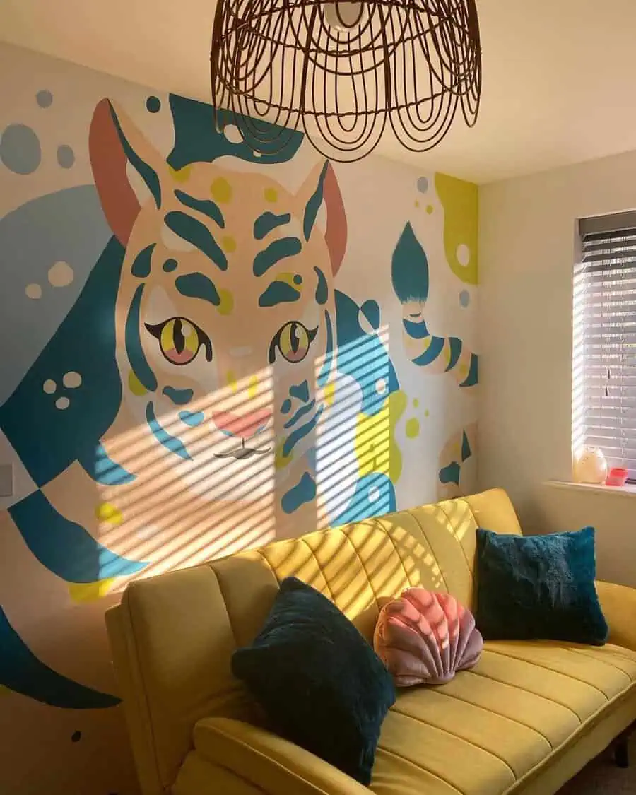 Room with a pale yellow sofa, teal pillows, pink shell cushion, and a bold tiger wall mural.