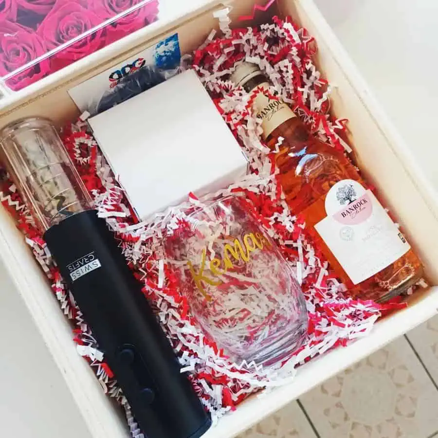 Personalized gift box with wine, glass, electric corkscrew, and decorative packaging.