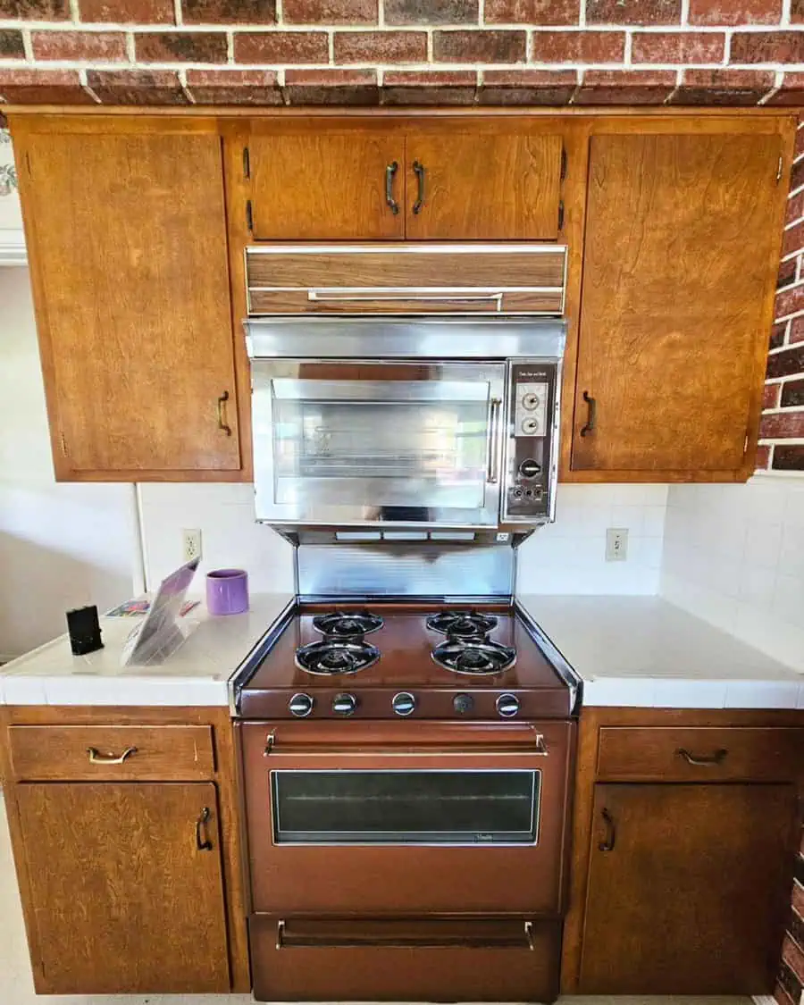 Retro 1950s kitchen featuring stainless steel appliances and colorful tiled backsplash.