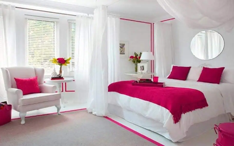 Bright bedroom with round mirror, fuchsia accents, and airy white curtains.