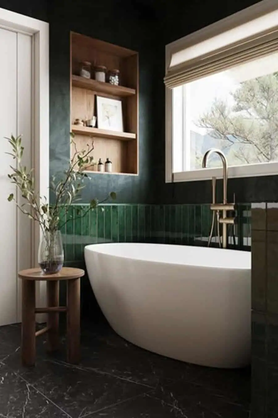 Small luxury bathroom with green tile accents, freestanding tub, wood shelving, and black marble floor.