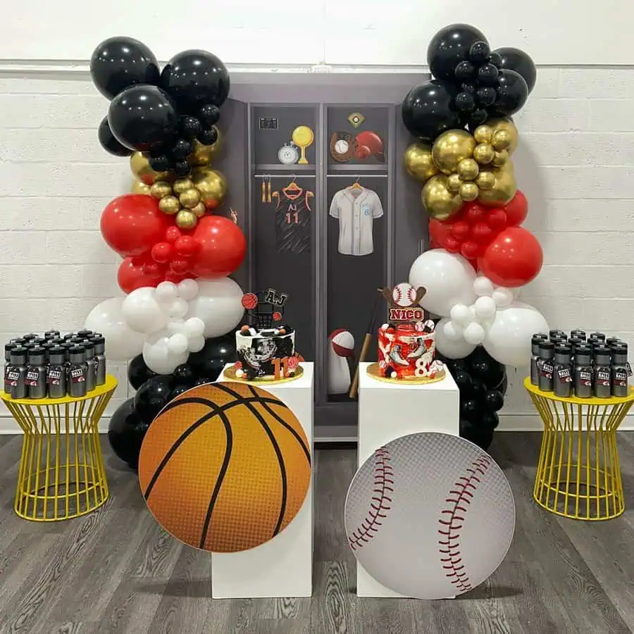 Sports-themed birthday party with basketball and baseball decor, balloon arches, and themed cakes.