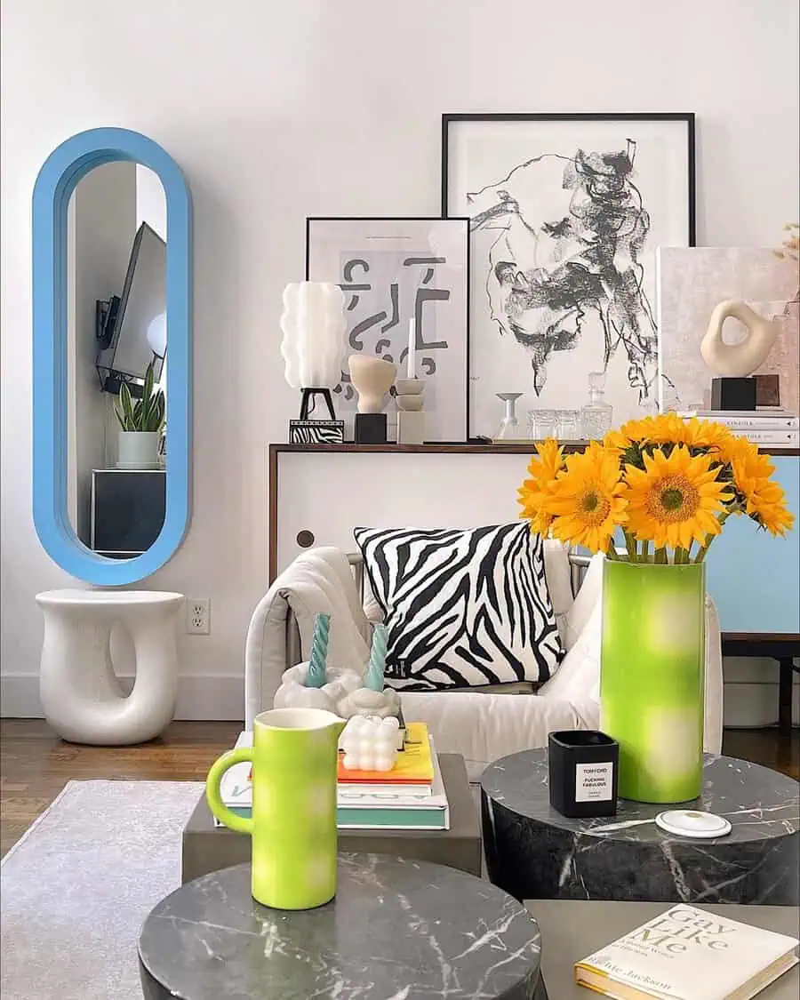 Vivid studio apartment with bold decor, abstract artwork, sunflowers, and marble accent tables.