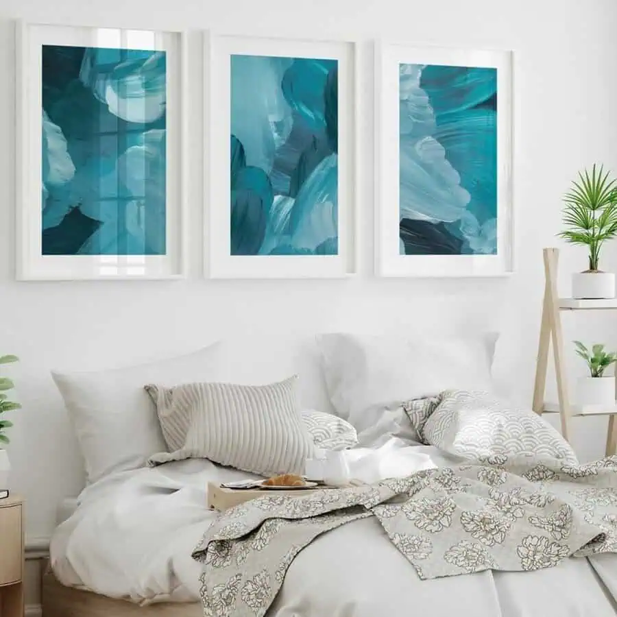 A serene teal-themed gallery wall paired with neutral bedding creates a calm, modern ambiance in this space.