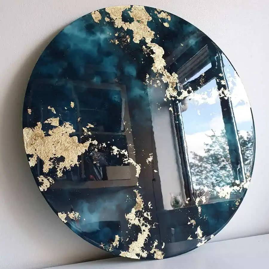 This large teal mirror with gold accents creates a dramatic focal point, adding depth and luxury to the living room.