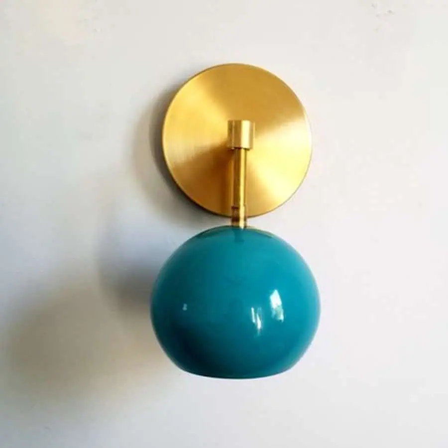 Minimalist teal wall sconce with a gold base, perfect for adding a modern touch to your living room.