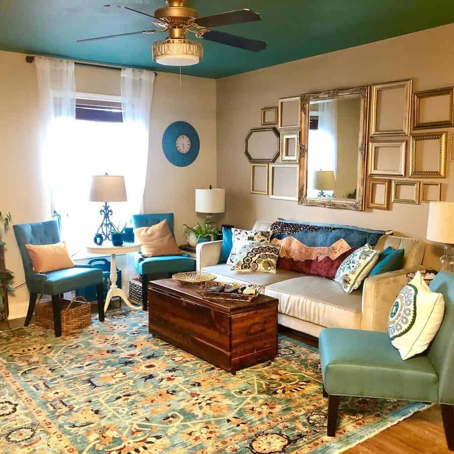 Living room with a teal-painted ceiling, vibrant patterns, and golden accents for a cozy, eclectic vibe.