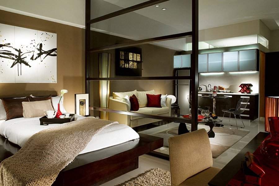Luxurious studio apartment with warm tones, textured accents, and an open kitchen-living layout.