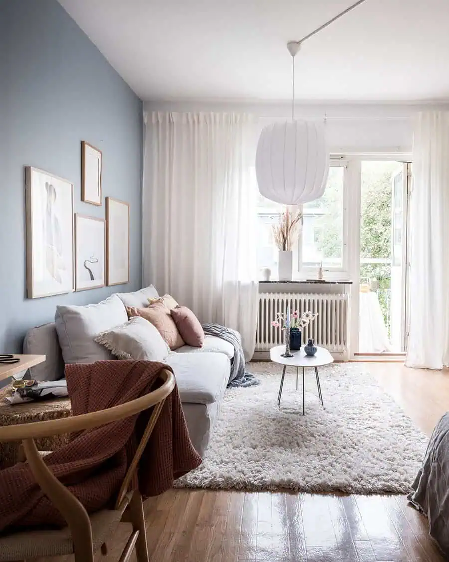 Scandinavian-style studio apartment with pastel walls, cozy decor, and soft natural light.