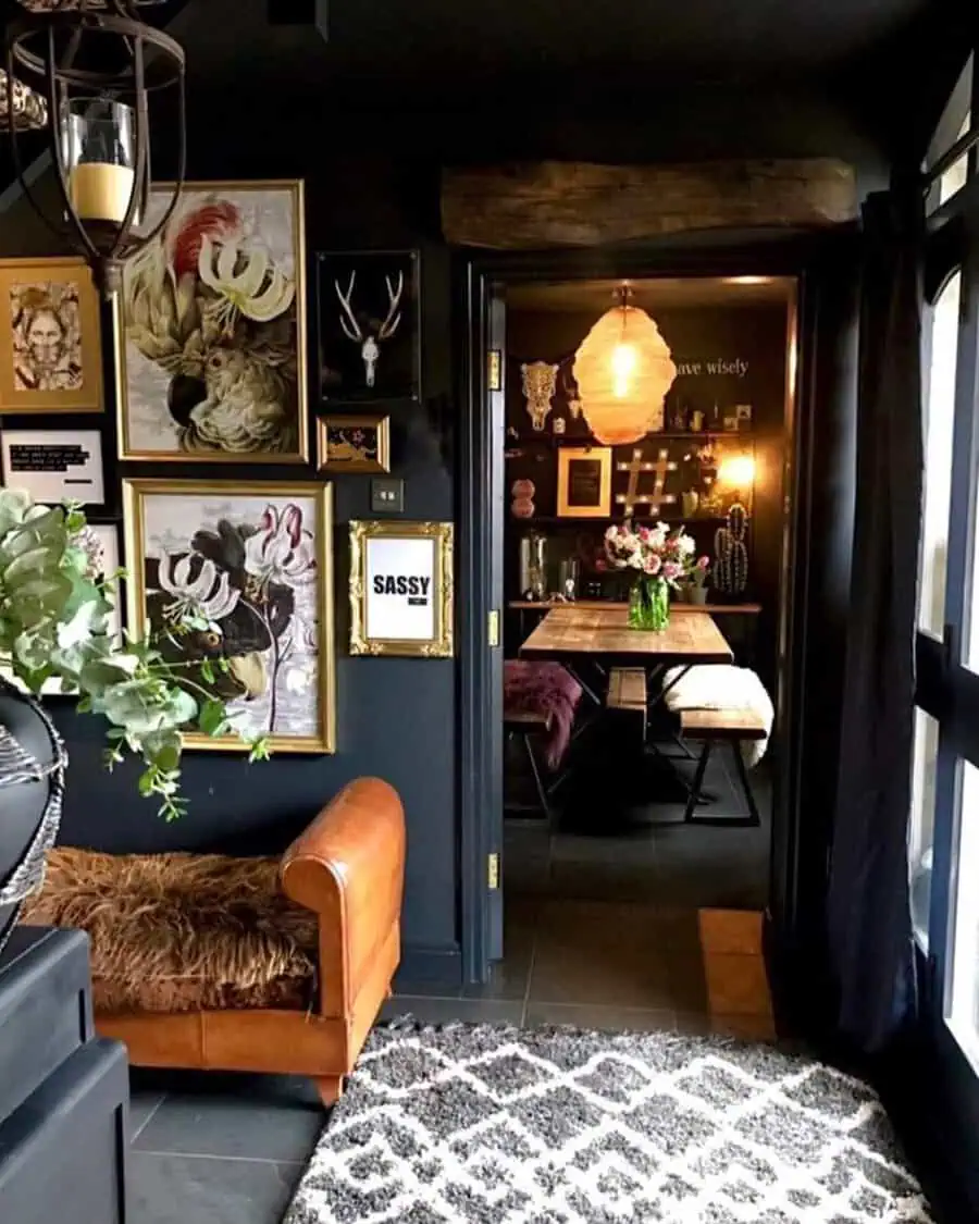 Dark eclectic interior with vintage art, leather seating, and a cozy dining nook with warm lighting.
