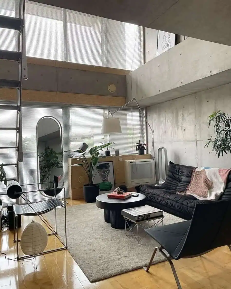 Industrial studio apartment with high ceilings, vintage rug, and sleek modern furniture.