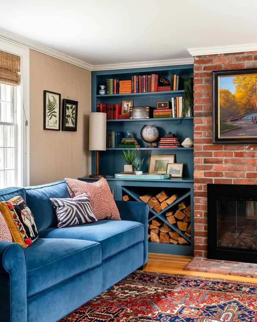 Blue sofa with vibrant pillows, built-in bookshelf with decor items, brick fireplace, and warm-toned rug.